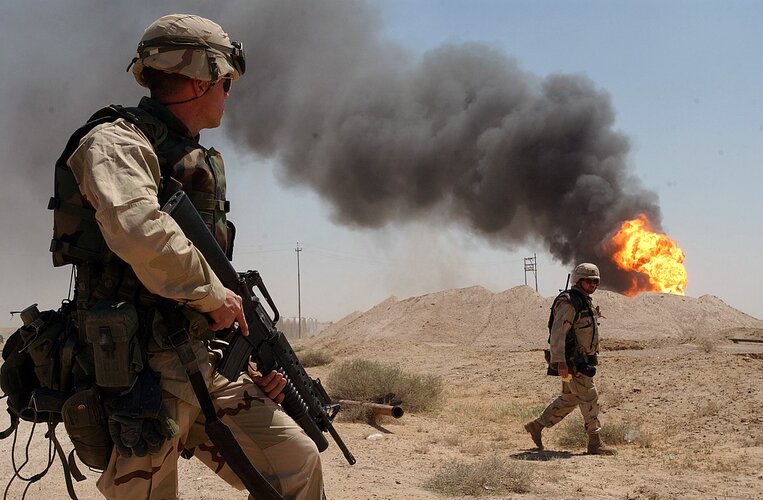 US_Navy_030402-N-5362A-004_U.S._Army_Sgt._Mark_Phiffer_stands_guard_duty_near_a_burning_oil_we...jpg