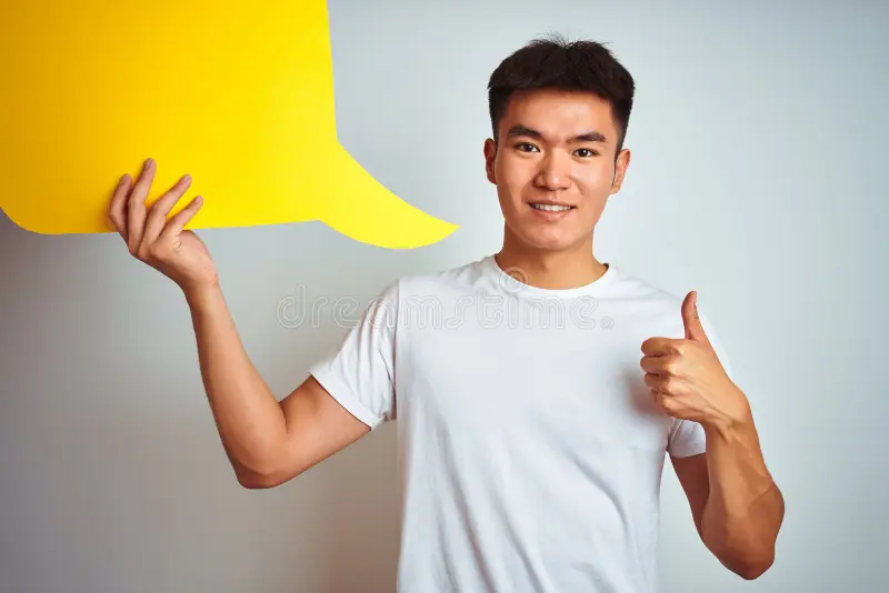 Asian chinese man holding speech bubble standing over isolated white background happy big smi