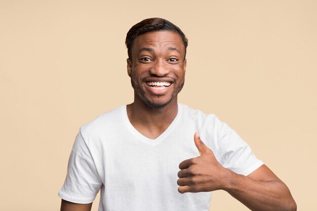afro-guy-gesturing-thumbsup-smiling-camera-yellow-background_922936-30763.jpg