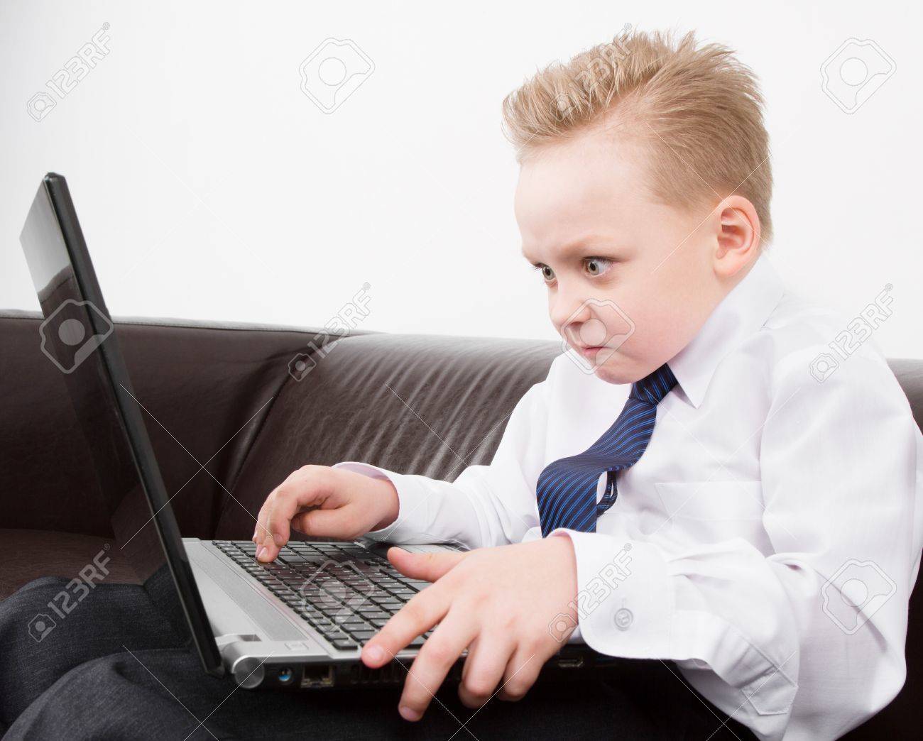33607431 angry boy in suit working at the computer