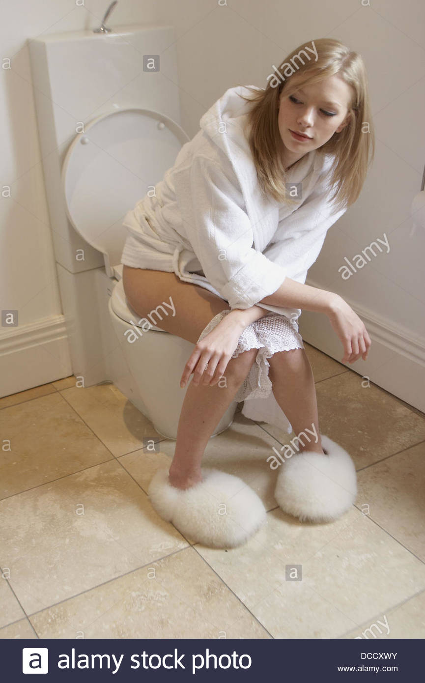 Girl sitting on the toilet with pants round her ankles DCCXWY