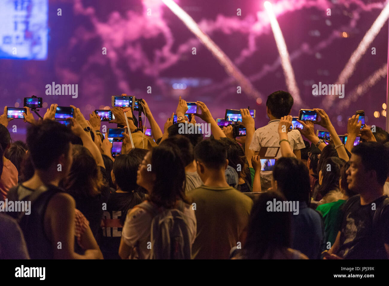 Crowd of asian people video recording fireworks on mobile phones instead JPJ39X