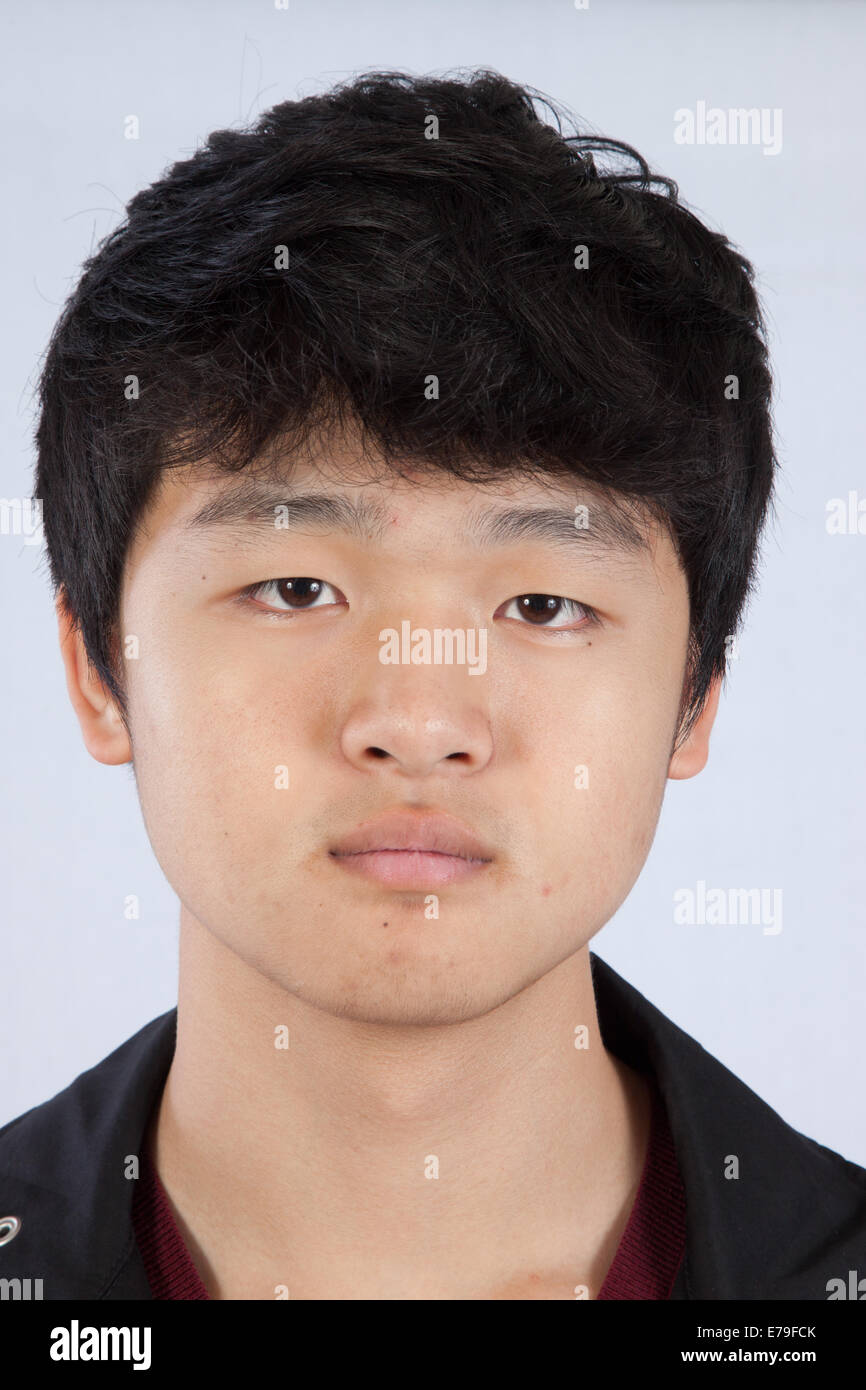 Handsome east asian man looking thoughtfully at the caamera E79FCK