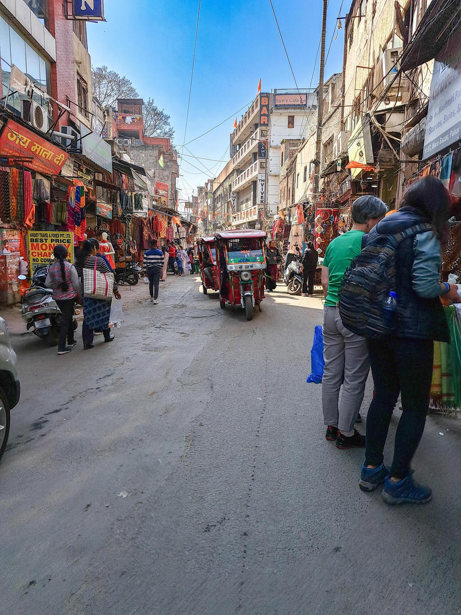 25 apr 2024 new delhi india dirty street pedestrians crossing street rickshaws carrying goods 