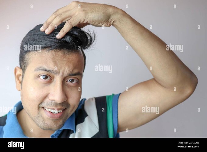a-young-indian-male-styling-is-hair-with-hands-and-a-positive-expression-on-face-isolated-on-g...jpg