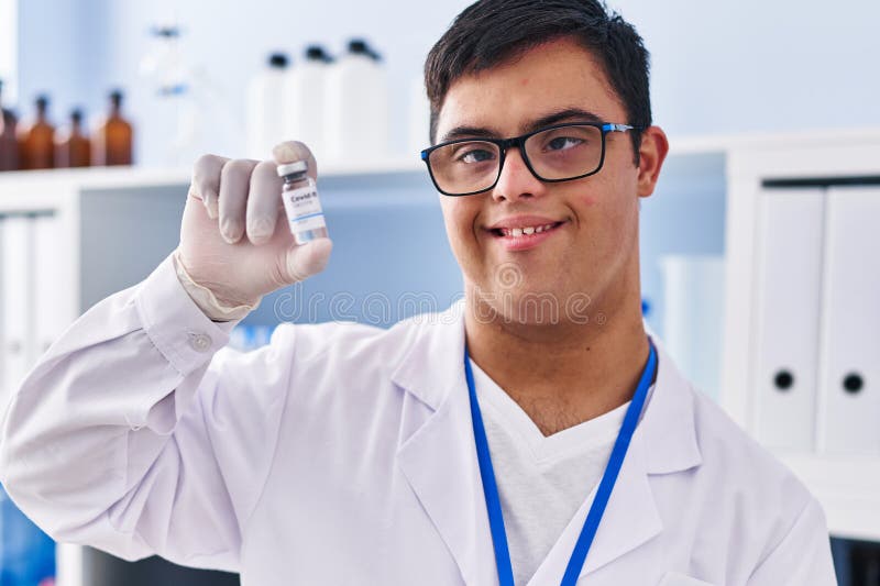 Down syndrome man wearing scientist uniform holding covid vaccine dose laboratory 258629136