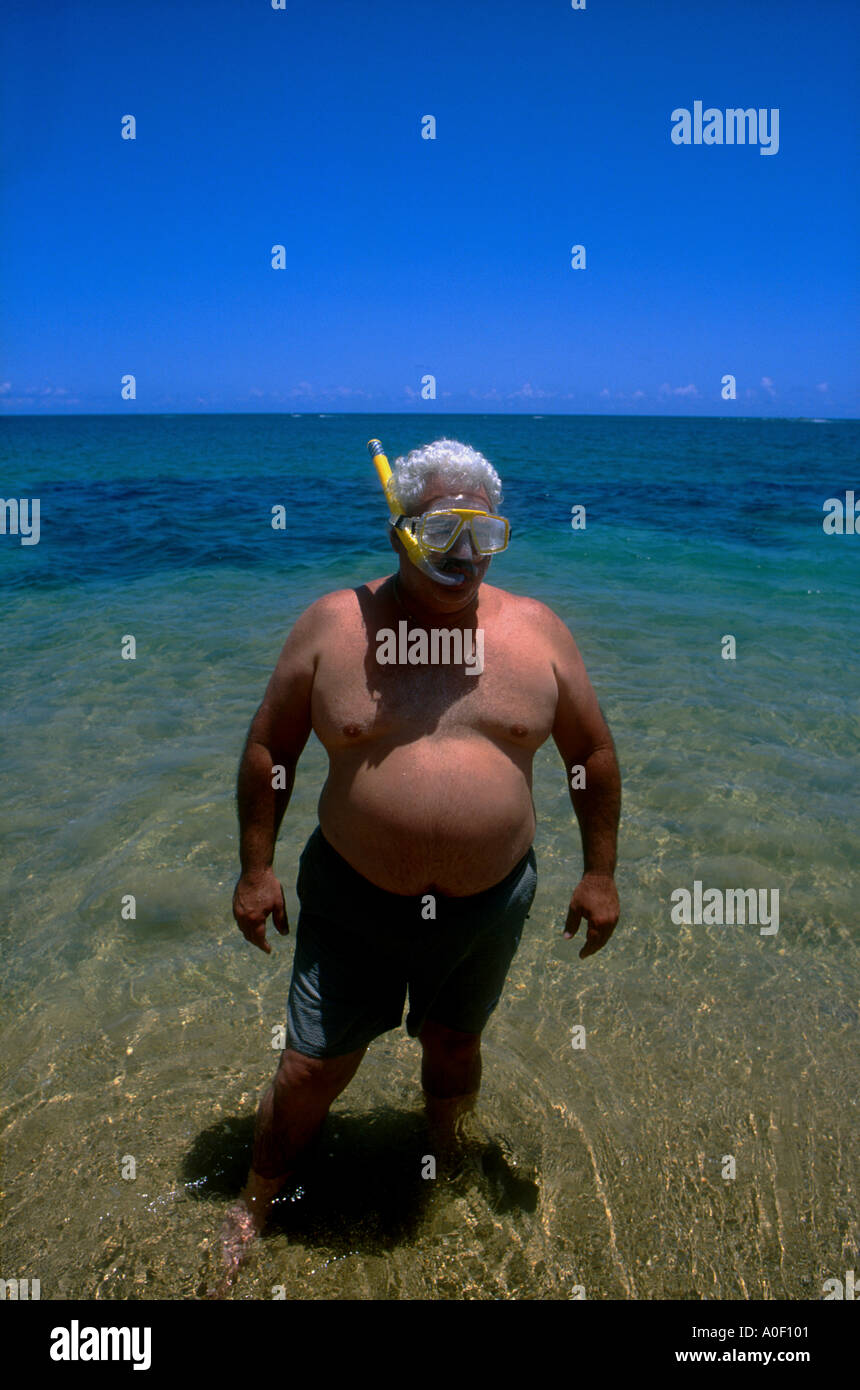 Heavy man at tropic beach standing still in water A0F101