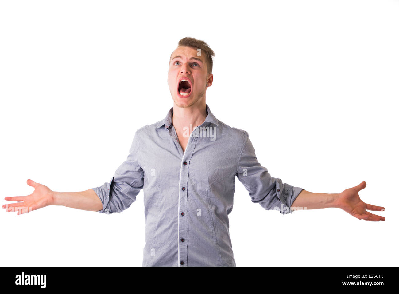 Desperate angry young man screaming with arms open and looking up E26CP5