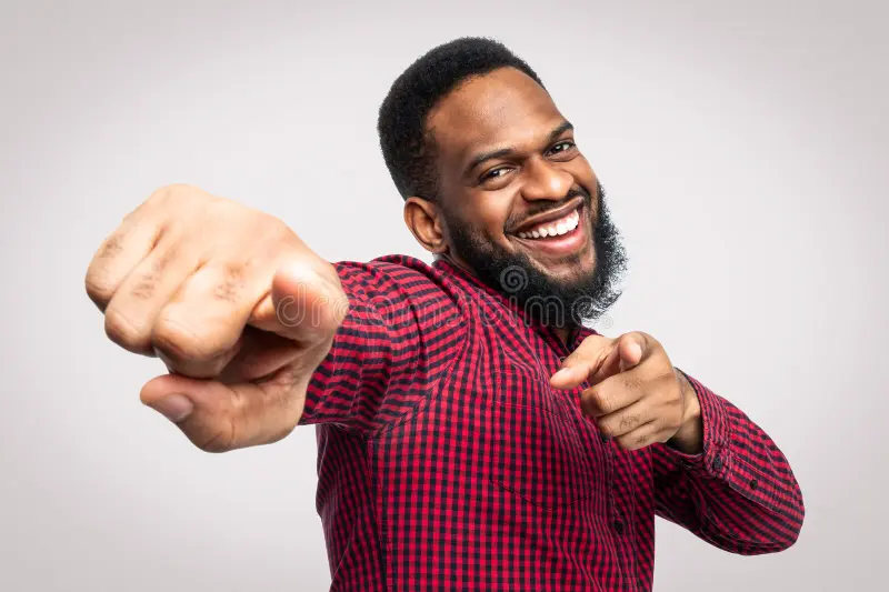 African man pointing fingers camera posing over white background hey you smiling american sta