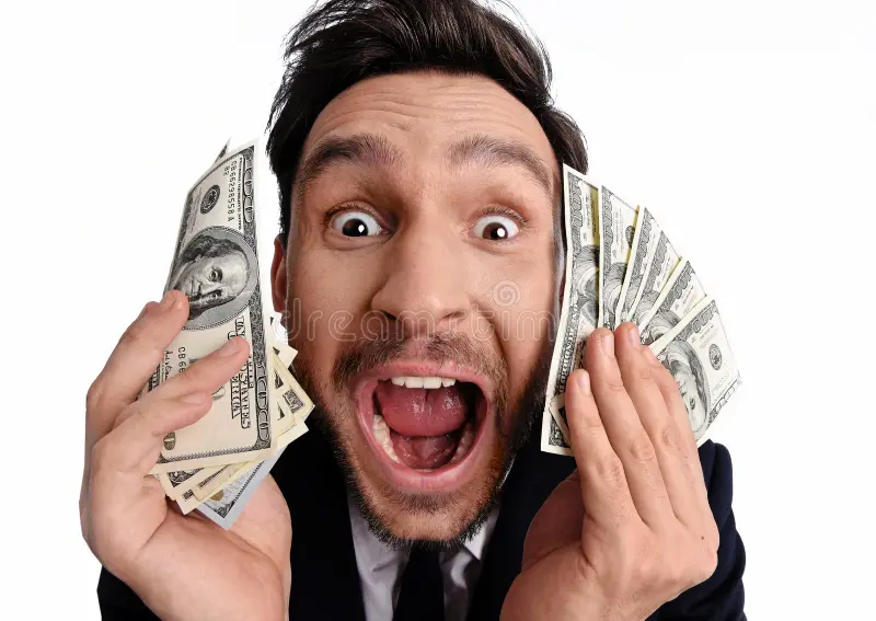 Lucky man holding dollar bill money his hand handsome bearded red shirt funny guy winner pile