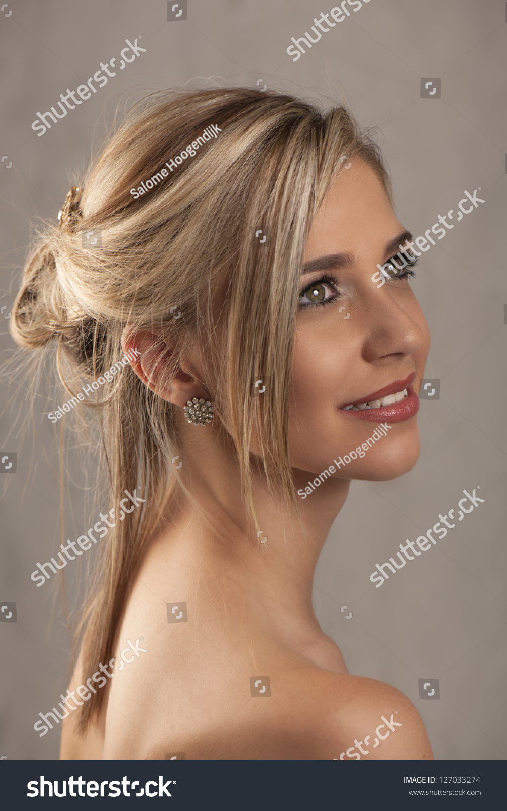 Stock photo portrait of beautiful blonde woman with hair tied up with gold and diamond hairpin