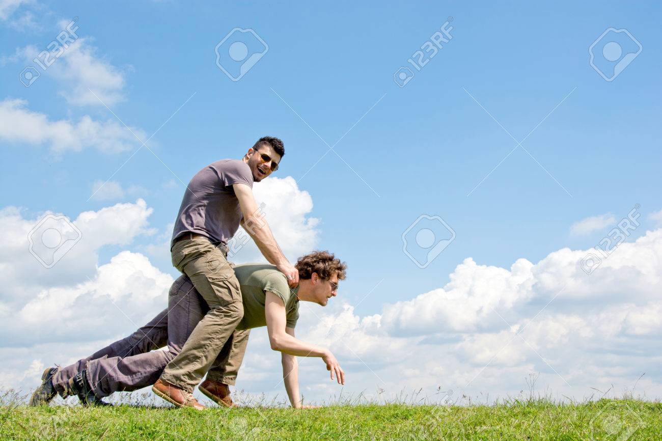 27840962 men riding one over another with fluffy clouds in background