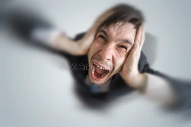 Young schizophrenic man suffers headache covering his ears hands 91233599