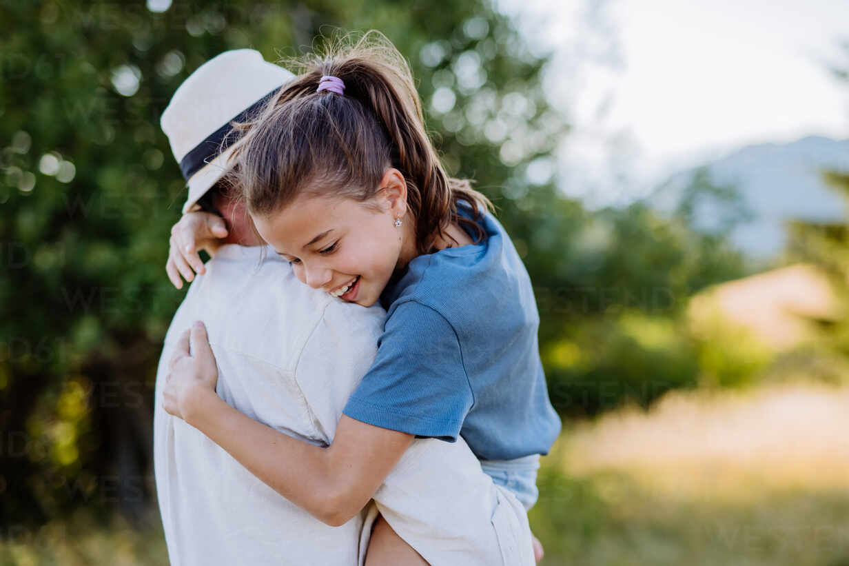 Un padre abrazando a su hija en verano en la naturaleza concepto del dia del padre HPIF10828